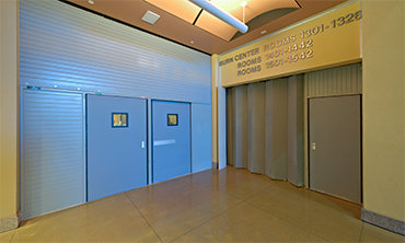 Side Acting Fire Rated Accordion Fire Door Providing Elevator Separation within an I-2 Occupancy